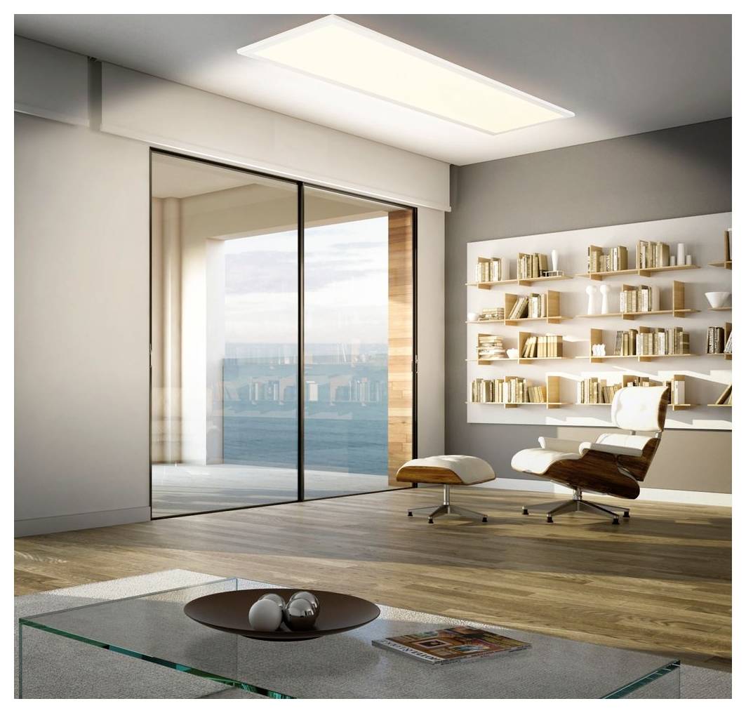Modernes Wohnzimmer mit raumhohen Schiebeglasvorsätzen, Loungesessel und Ottomane, Wandbücherregale und einem flachen Glaskaffeetisch mit Blick auf Wasser im Freien.