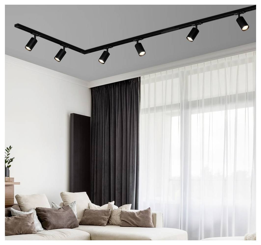 Modernes Wohnzimmer mit beigem Ecksofa, dunklen Vorhängen, großem Sheer-Fenster und schwarzer Schienensystem-Beleuchtung an der Decke.