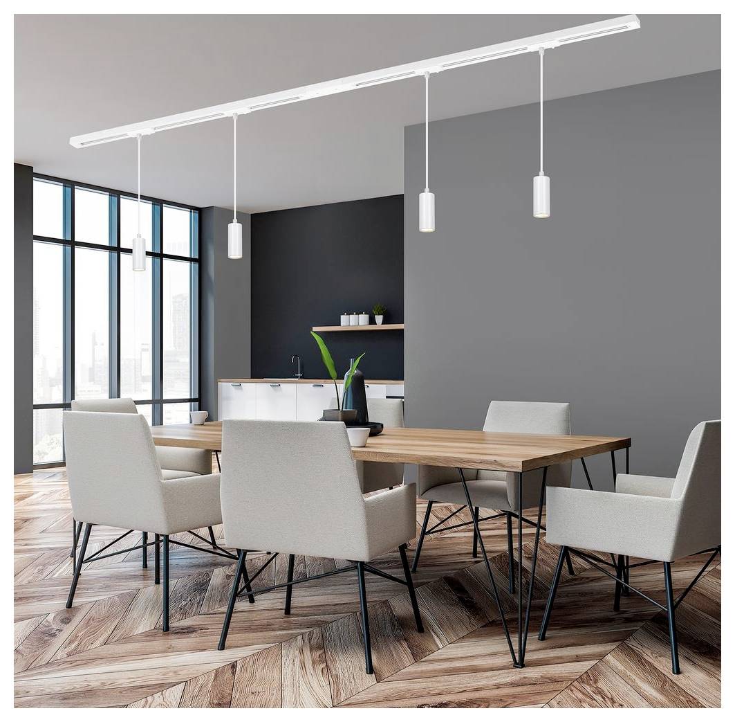 Modernes Esszimmer mit Holztisch, sechs leichten Stühlen, Pendelleuchten, großen Fenstern und einem kleinen Küchenbereich an grauen Wänden.