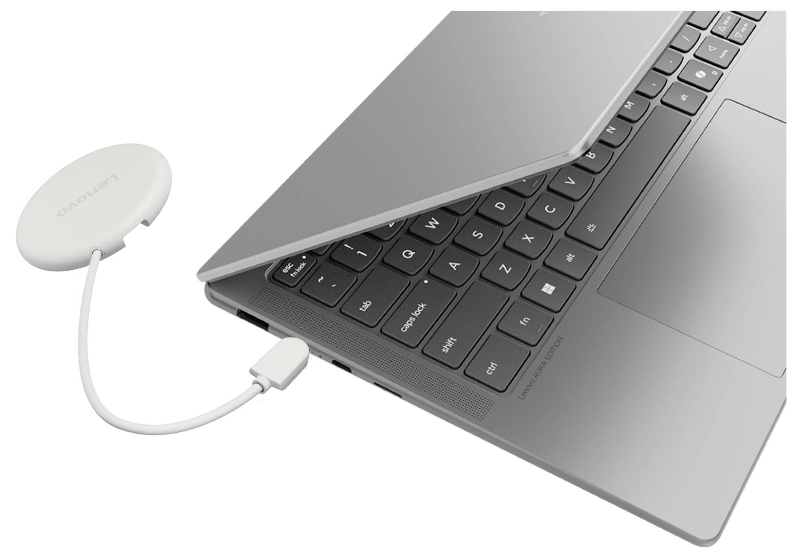 Ein Laptop, der per Kabel mit einem kleinen runden drahtlosen Zubehör verbunden ist, was auf einen Adapter oder Empfänger hindeutet, der in den Computer eingesteckt ist.