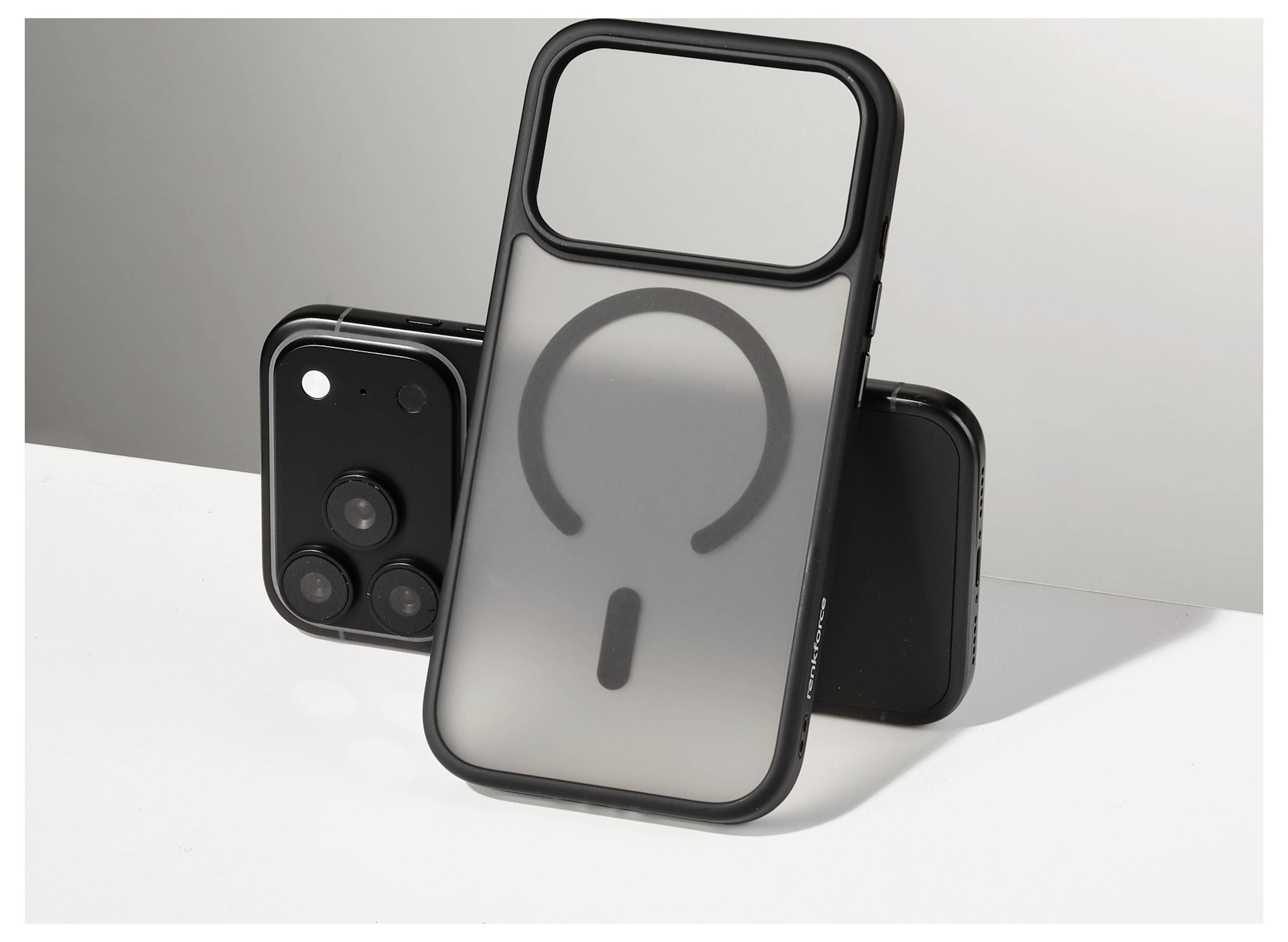 Drei Smartphone-Hüllen auf einer weißen Oberfläche angezeigt, wobei die vordere Hülle einen großen MagSafe-ähnlichen Ring und eine Aussparung für die Kameraleiste zeigt.