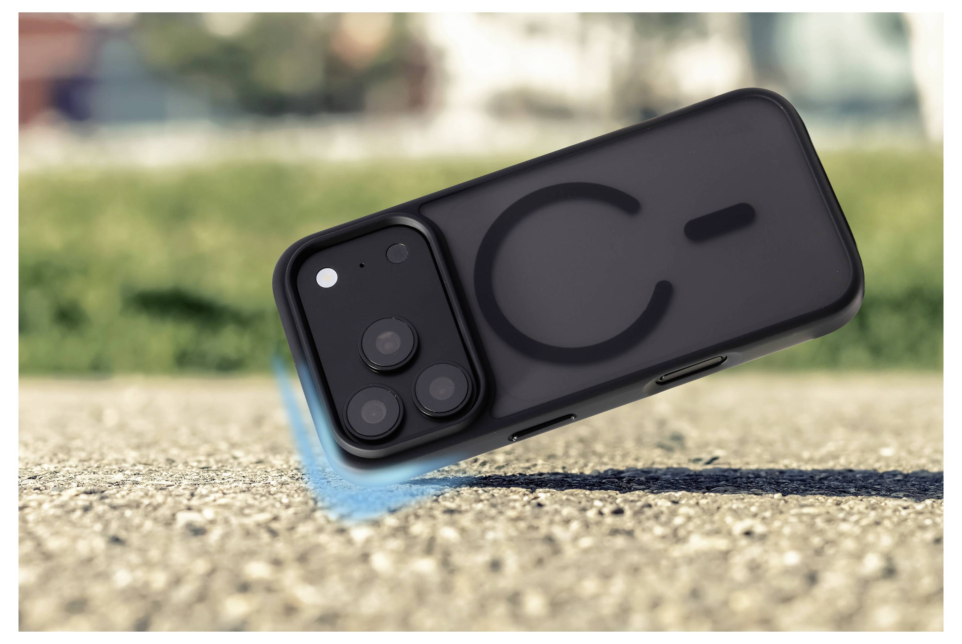 Smartphone in einem schwarzen Etui auf einer Kieselfläche geneigt, mit einer blauen Bewegungsunschärfe, die darauf hindeutet, dass es gleitet oder fällt.