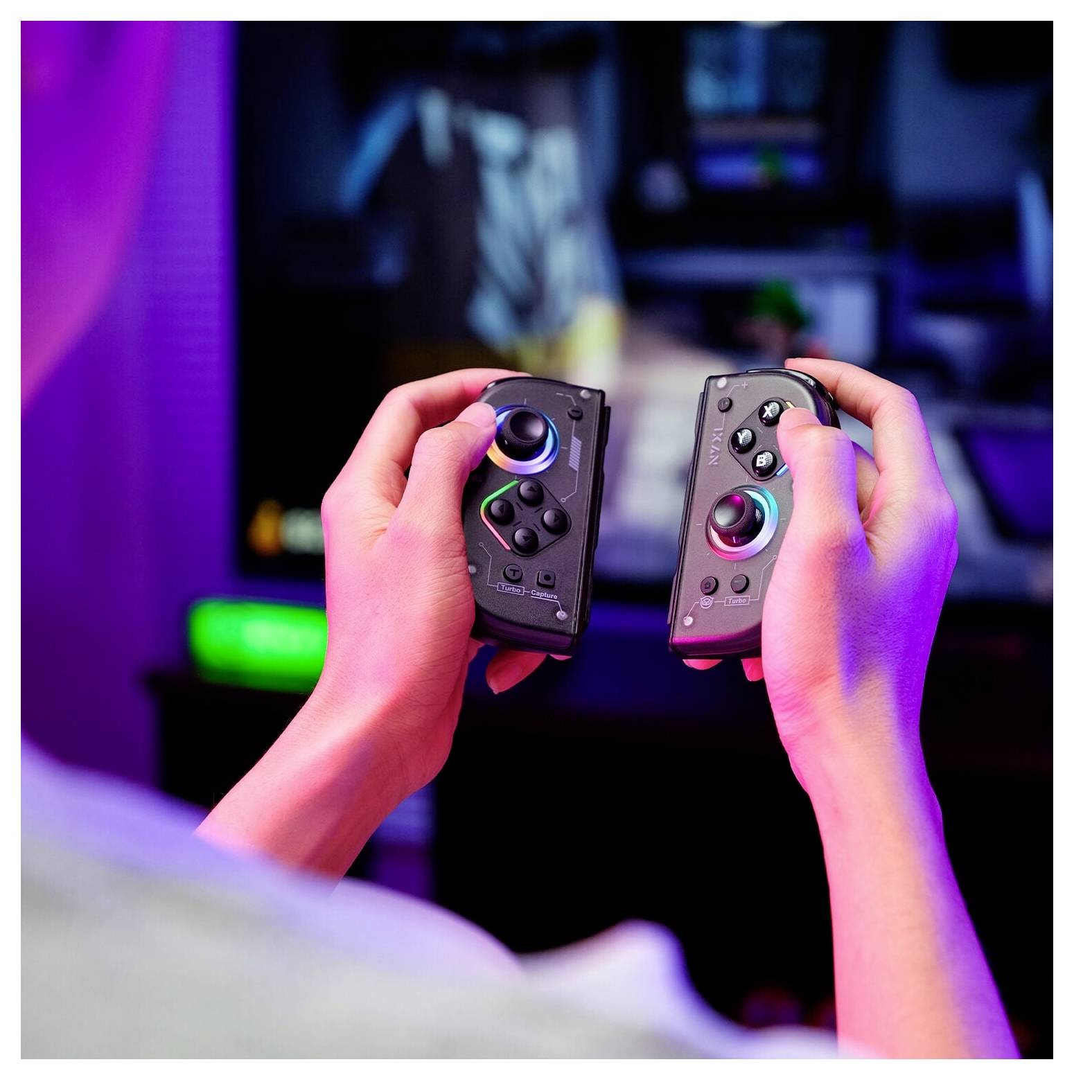 Hände halten zwei Nintendo Switch Joy-Con-Controller vor einem unscharfen TV-Gaming-Setup mit farbenfroher Neonbeleuchtung.