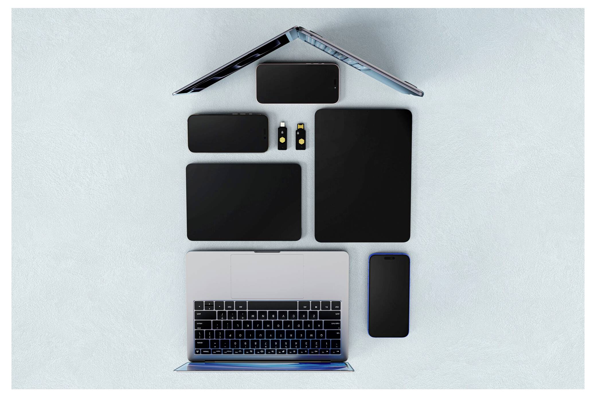Mehrere elektronische Geräte, die als Haus angeordnet sind: zwei offene Laptops bilden das Dach und die Basis, mit Tablets und Telefonen als Fenster und Wände.