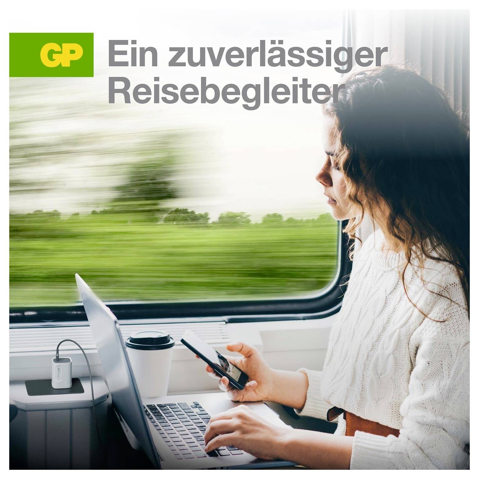 Frau nutzt Laptop und Telefon in einem Zug neben dem Fenster, mit GP-Logo und deutschem Text „Ein zuverlässiger Reisebegleiter