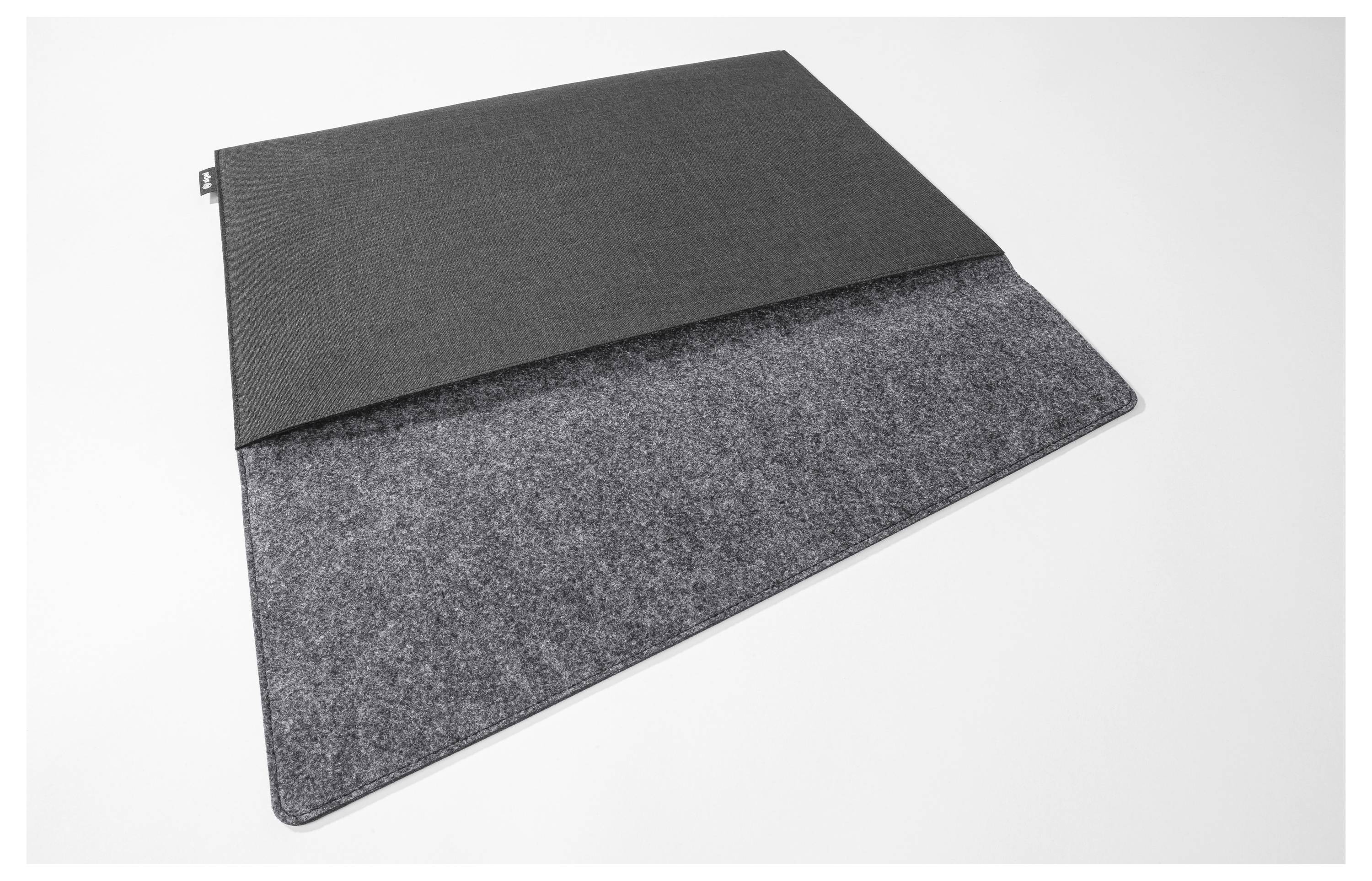 Ein dunkelgraues Filz-Futteral oder eine Matte, die über ein größeres strukturiertes graues Panel auf weißem Hintergrund gefaltet ist.