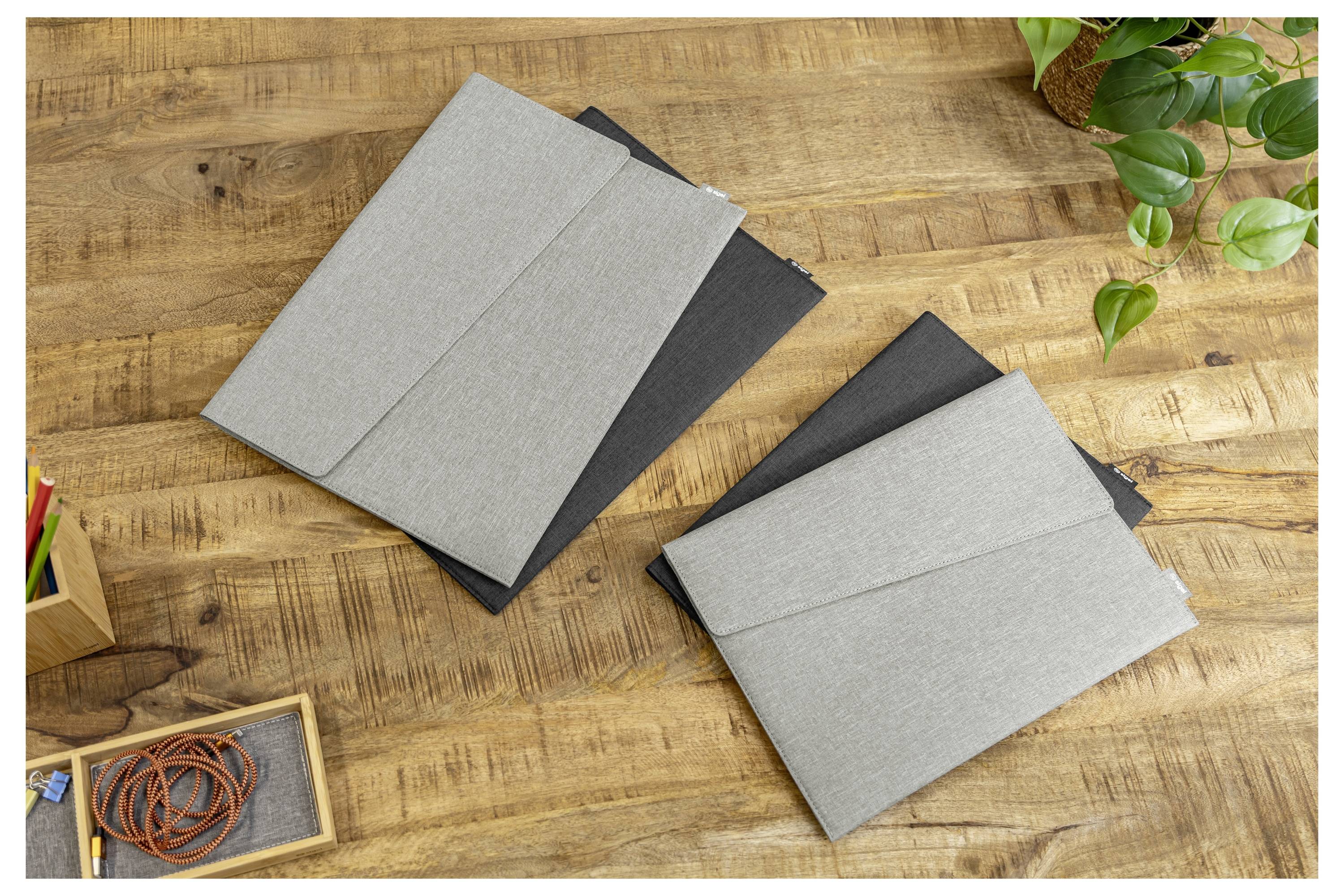 Zwei graue Filz-Laptop-Taschen auf einem Holzschreibtisch, mit einer Pflanze und kleinen Büroartikeln herum.