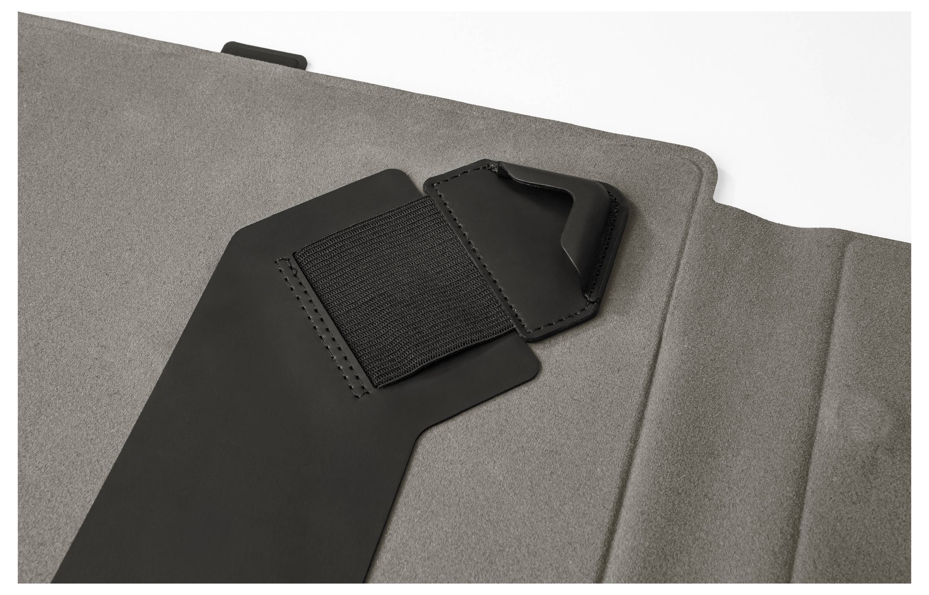 Nahaufnahme eines schwarzen Laptop-/Tablet-Schutzhüllen-Riemens und einer magnetischen Klappe auf einer grauen Stoffhülle.