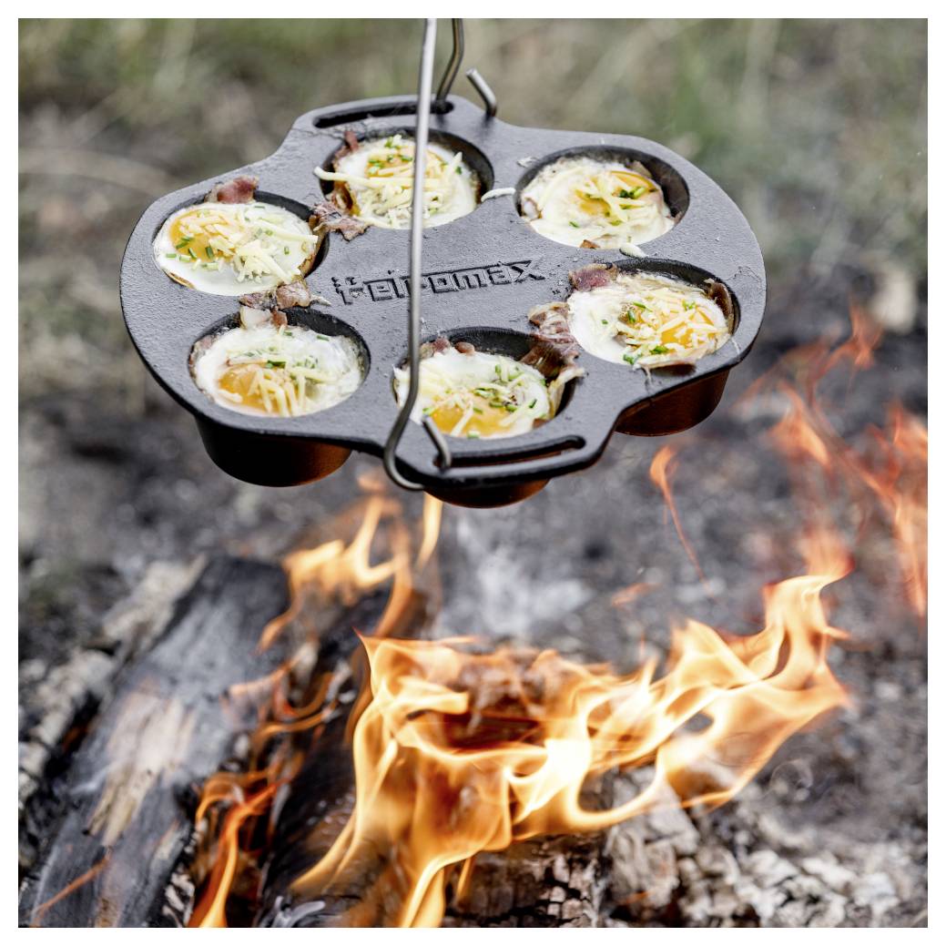 Gusseisen-Campfire-Pfanne kocht sechs Ei-und-Käse-Häppchen über offenen Flammen