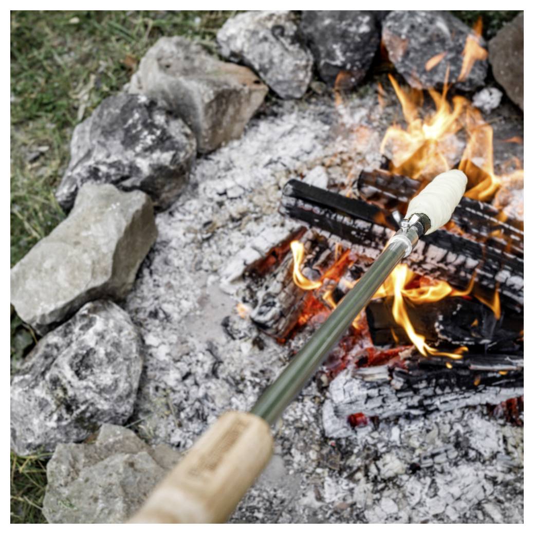 Ein Marshmallow auf einem Röststock, der über einem Lagerfeuerring mit Steinen und brennenden Holzscheiten gehalten wird.