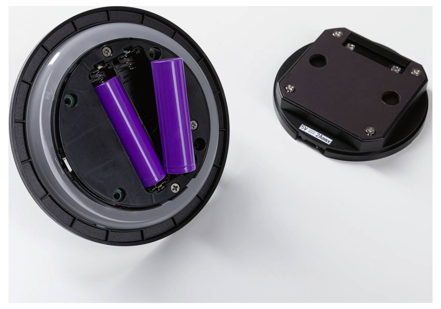 Öffnen Sie das Batteriefach mit zwei lila Batterien, die neben der abgenommenen Abdeckung gezeigt werden.