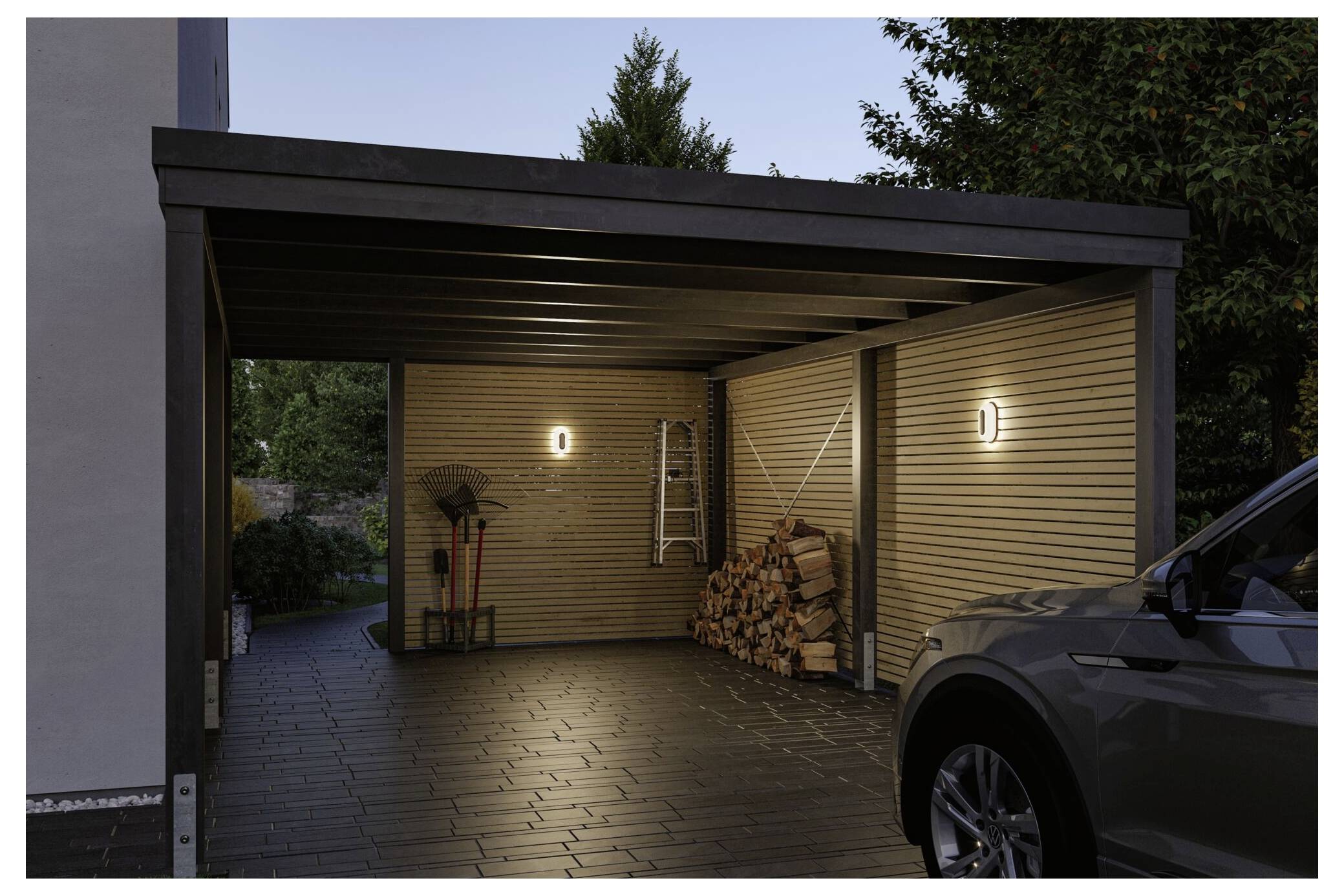 Moderner Carport in der Dämmerung mit zwei Wandleuchten, gestapeltem Feuerholz, einer Leiter und einem geparkten Auto davor