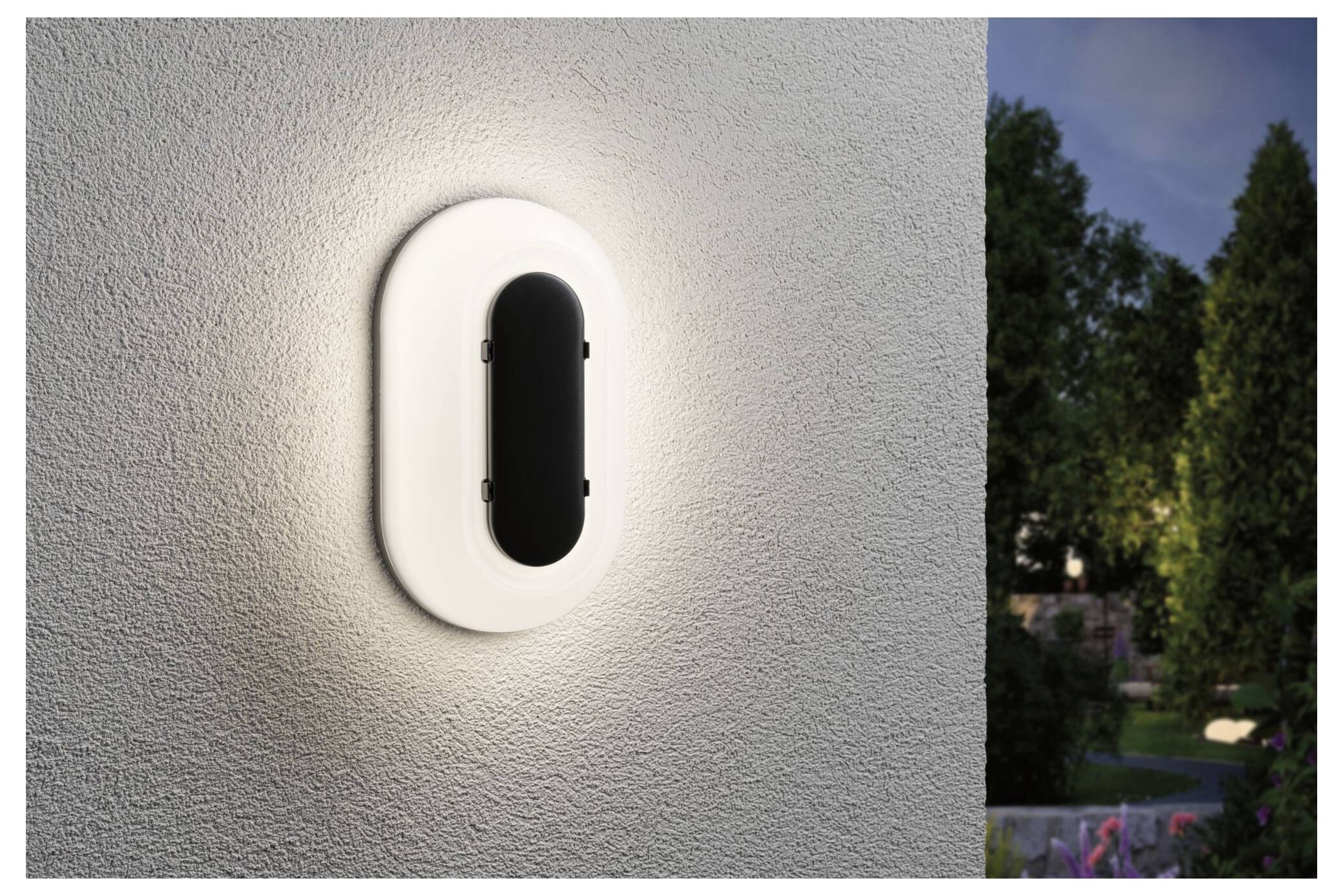 Moderne ovale Wandleuchte auf einer strukturierten Außenwand, die sanft neben einer Außenszene in der Abenddämmerung leuchtet.