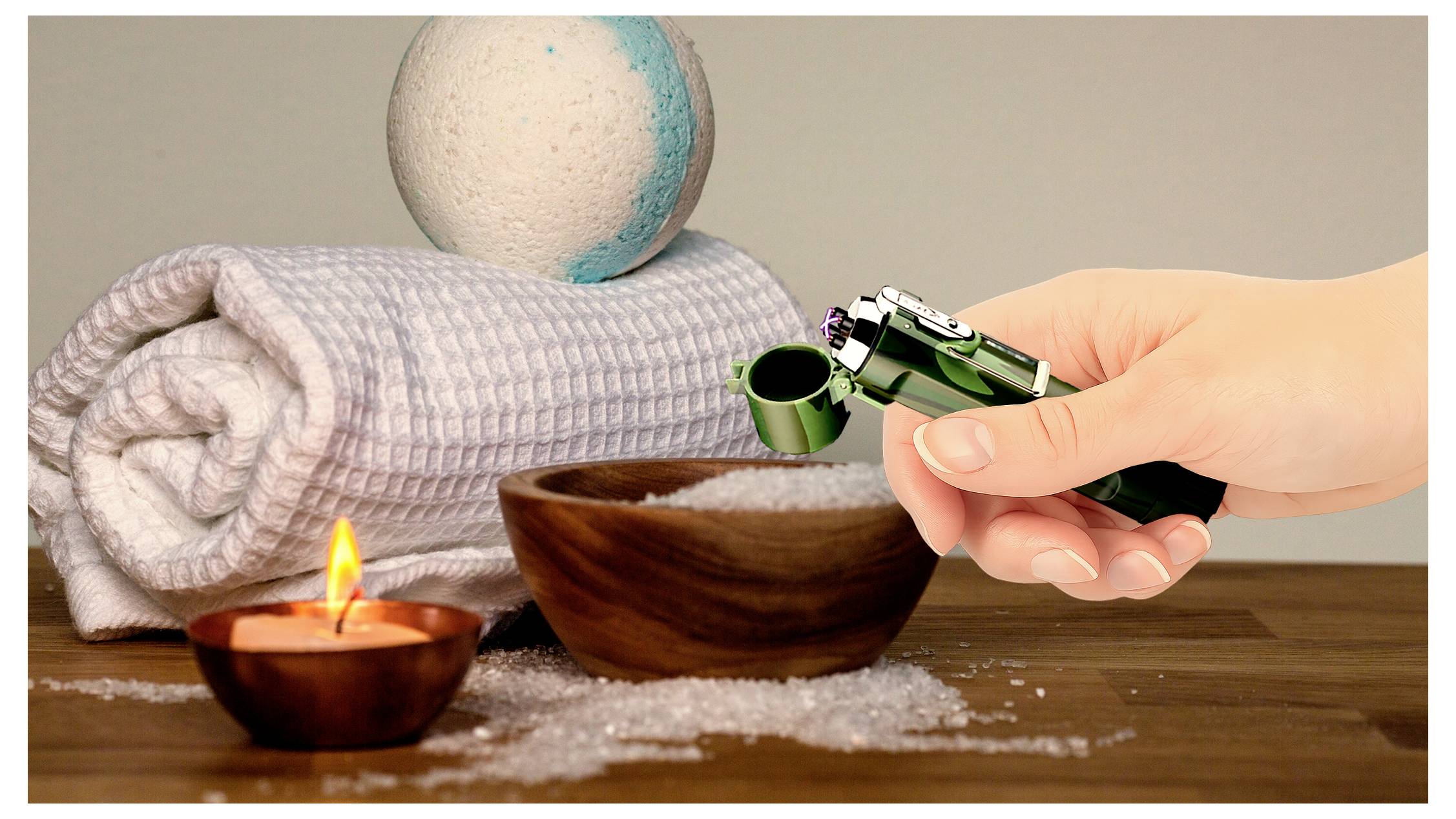 Eine Hand benutzt ein Feuerzeug, um eine kleine Schale zu entzünden, mit einem aufgerollten Handtuch, einer Badebombe und Salz auf einer Holzoberfläche.