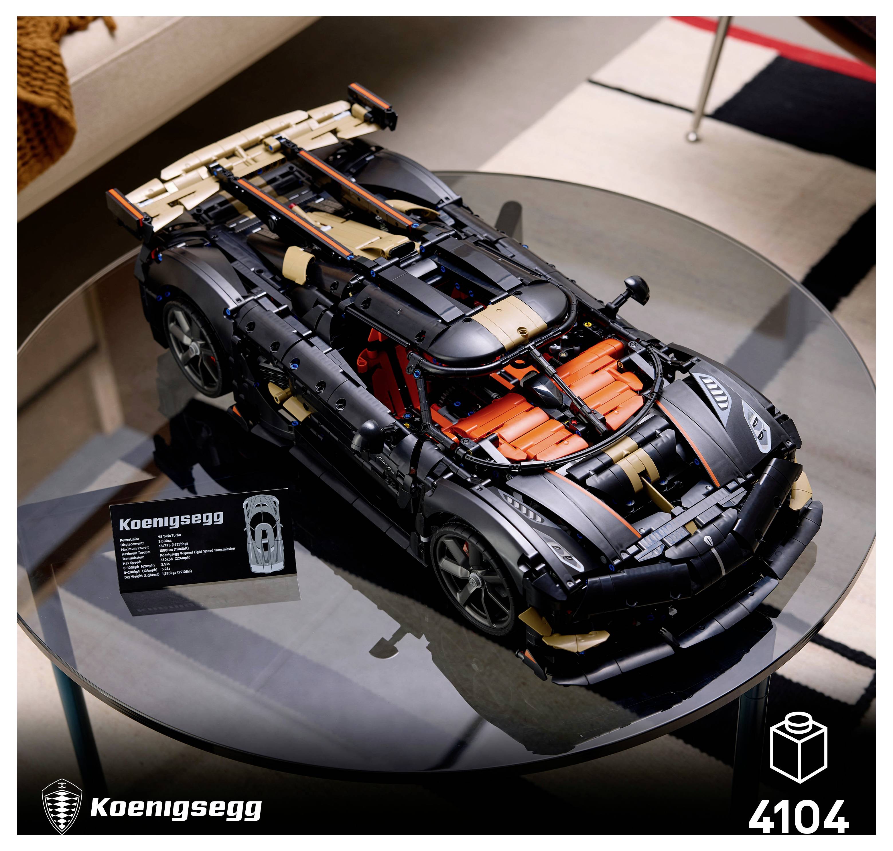 LEGO Koenigsegg Supersportwagen-Modell auf einem Displaytisch, mit freigelegten mechanischen Details und orangefarbenen Motorteilen, bezeichnet mit 4104.