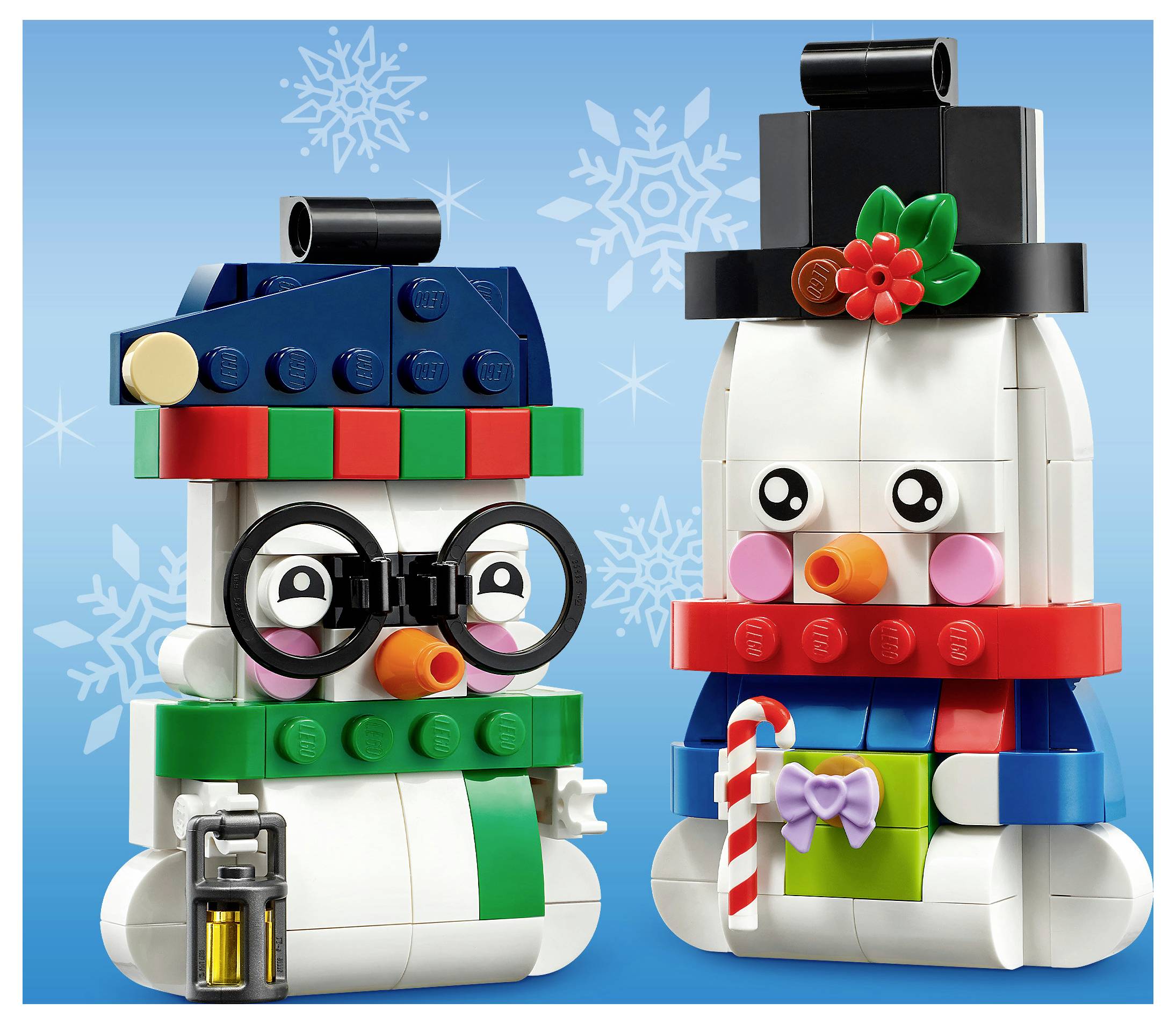 Zwei LEGO-Schneemann-Figuren, eine mit Brille und einer Laterne, die andere mit einem Zylinder und einer Zuckerstange, vor einem verschneiten blauen Hintergrund posiert.