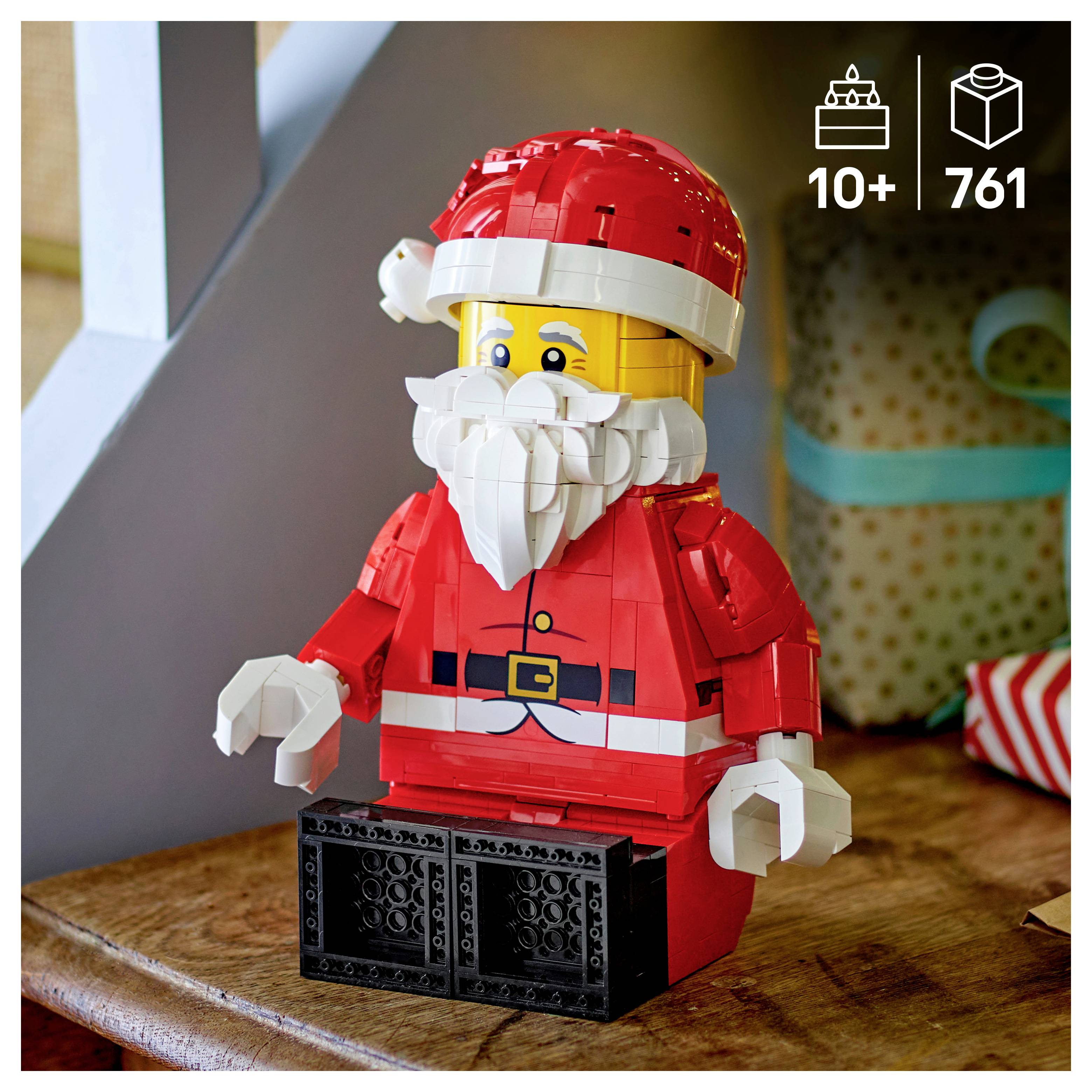 LEGO Weihnachtsmann-Modell in rotem Anzug und Mütze mit weißem Bart, sitzend auf einer Holzoberfläche; das Symbol zeigt 10+ Jahre und 761 Teile.