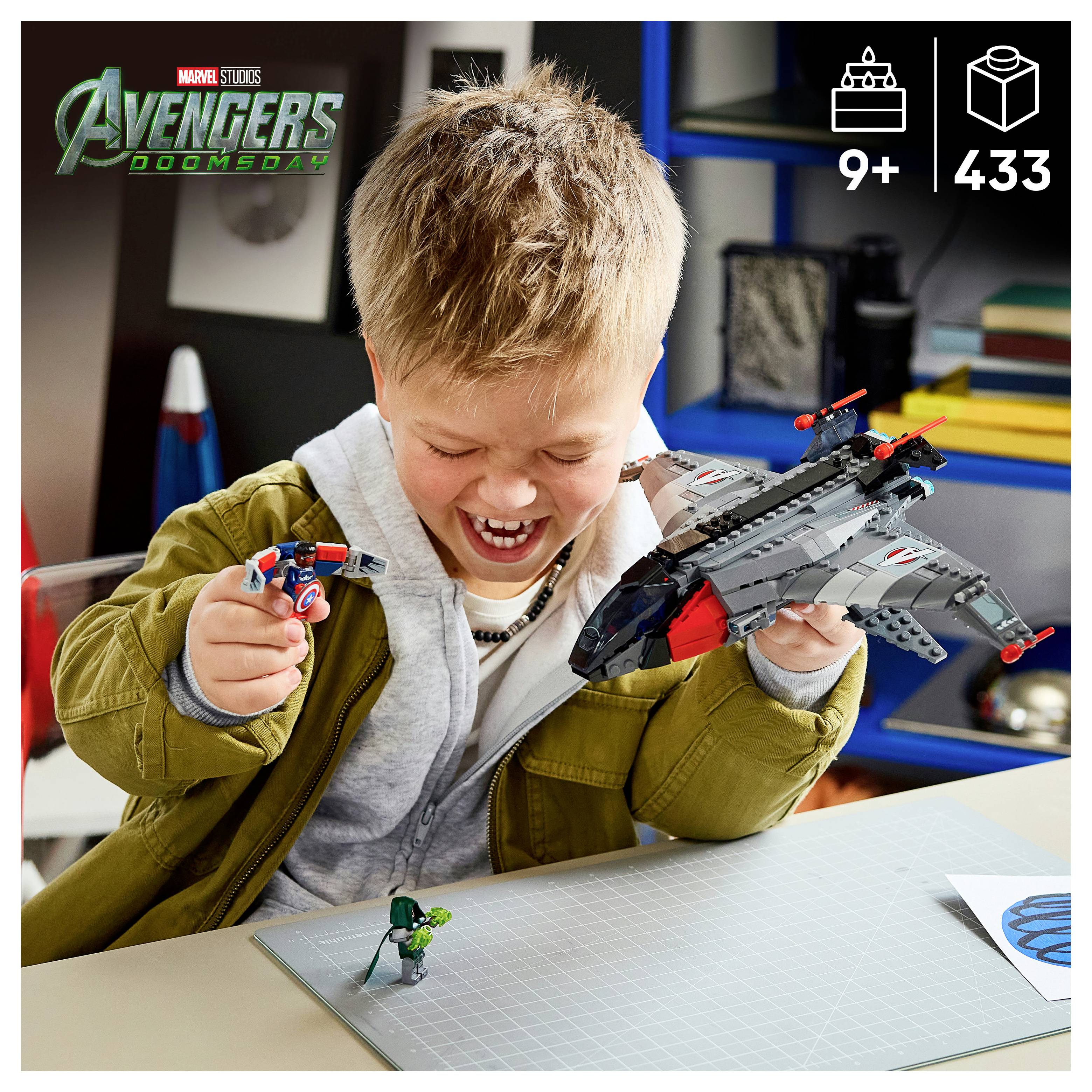 Lächelnder Junge spielt mit Avengers LEGO-Set, hält eine Captain America-Minifigur und einen grauen Jet; das Etikett zeigt '9+' und '433' Teile.