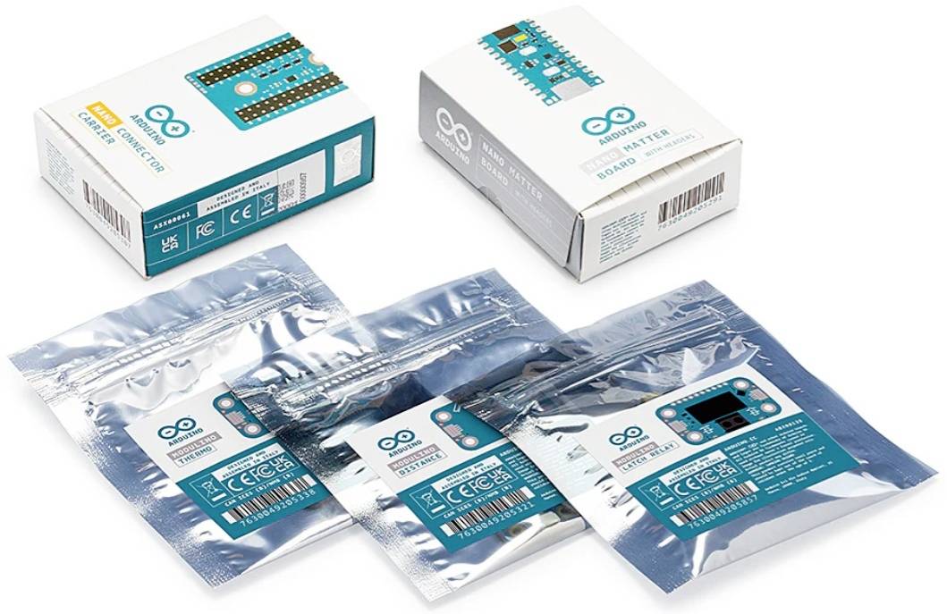 Arduino-Platinen im Einzelhandelsverpackung gezeigt als zwei Produktkartons und drei antistatische Beutel mit Platinen im Inneren.