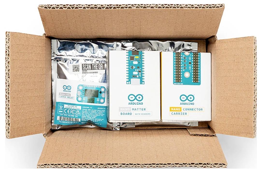 Offene Pappschachtel, die Arduino-Elektronik-Kits und Platinen in gekennzeichneter Verpackung enthält, darunter „Arduino Matter Board