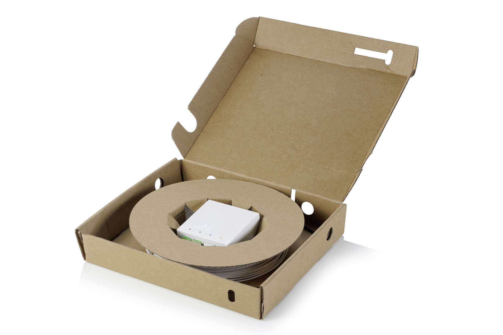 Offene Kartonversandbox mit einer aufgerollten braunen Papierband und einer kleinen weißen Geräteeinlage auf weißem Hintergrund.