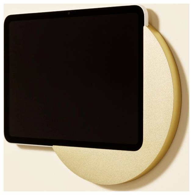 Schwarzes leeres rechteckiges Schild oder Bildschirm, das über einer großen goldenen kreisförmigen Rückwand an einer hellen Wand angebracht ist.