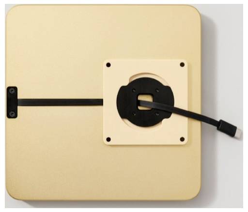 Nahaufnahme eines goldenen quadratischen Geräts oder Panels mit einem schwarzen Kabel, das in einen zentralen Anschluss führt, vermutlich zeigt ein Lade- oder Verbindungsschnittstelle.