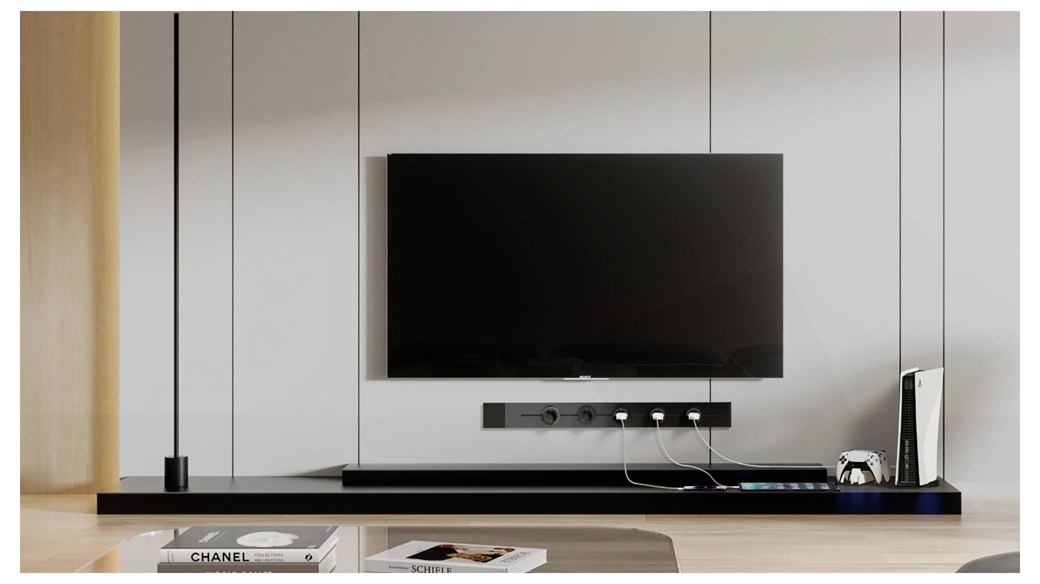 Modernes Wohnzimmer-Mediensetup mit an der Wand montiertem Fernseher über einem schwebenden Regal, Kabelverbindungen und einer Spielkonsole neben Büchern und Dekoration.