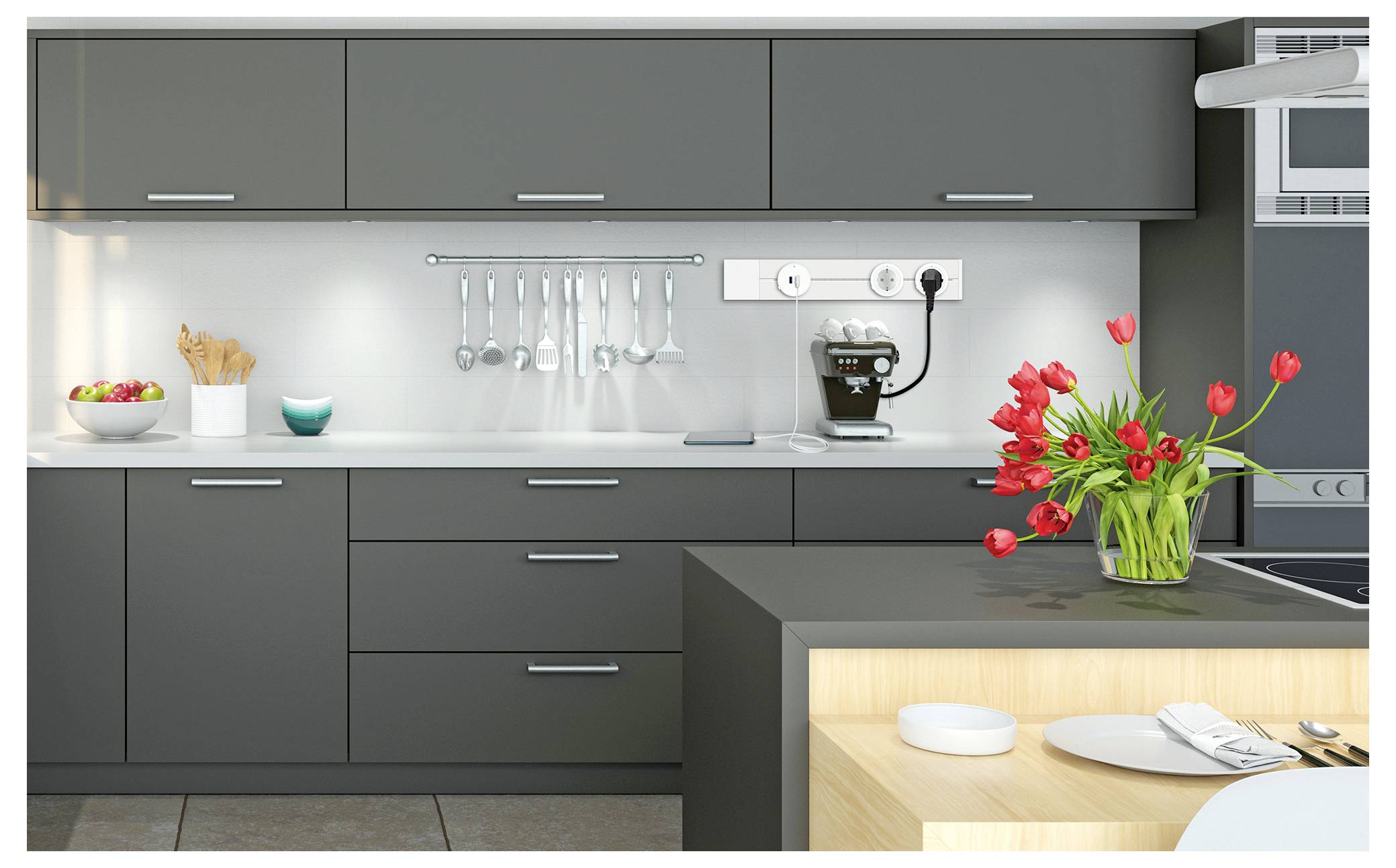 Moderne Küche mit dunkelgrauen Schränken, Arbeitsplattengeräten, Kaffeemaschine und einer Vase mit roten Tulpen auf der Insel