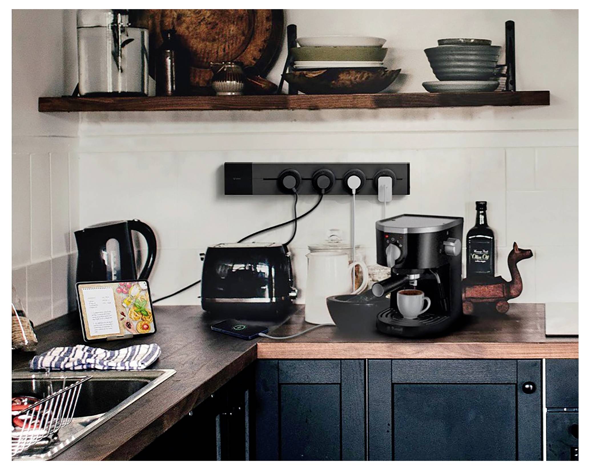 Küchentheke mit Toaster, Kaffeemaschine, Wasserkocher und Tasse neben einem Waschbecken und einem offenen Regal mit Geschirr; eine kompakte Kaffeestation.