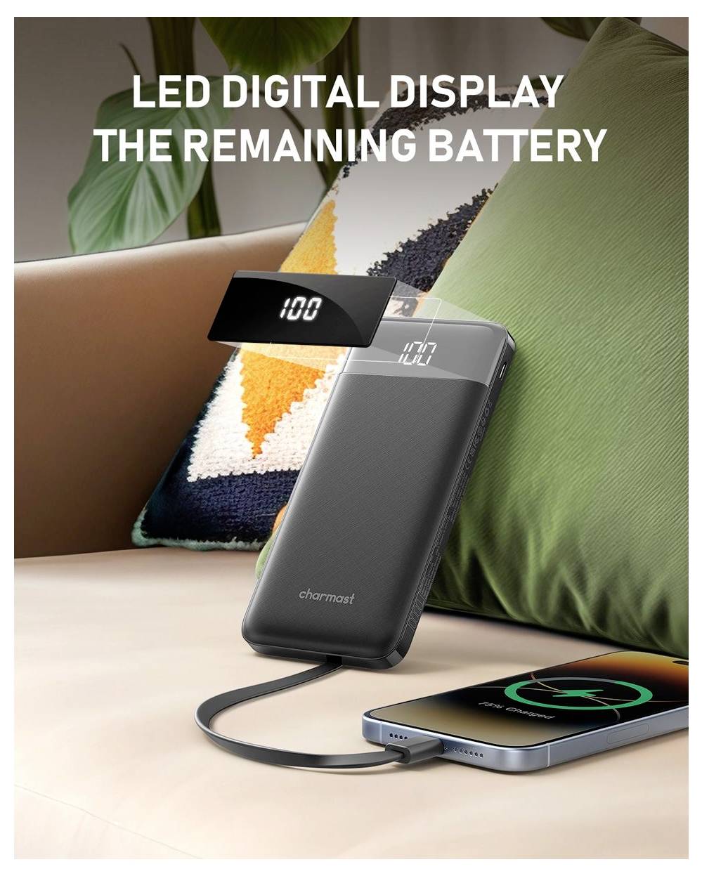 Tragbare Powerbank mit LED-Digitalanzeige, die die verbleibende Batterie bei 100% anzeigt, lädt ein Smartphone auf einem Sofa.