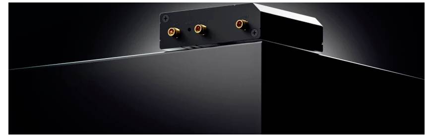 Schwarzes rechteckiges elektronisches Gerät mit drei leuchtenden Anschlüssen oben, dargestellt in einer dunklen produktstilisierten Nahaufnahme.