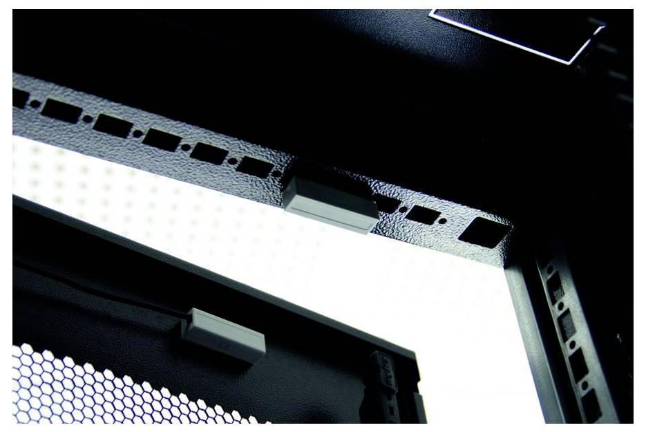 Nahaufnahme eines schwarzen Metallcomputergehäuserahmens mit Belüftungsschlitzen und einem weißen Paneel dahinter.