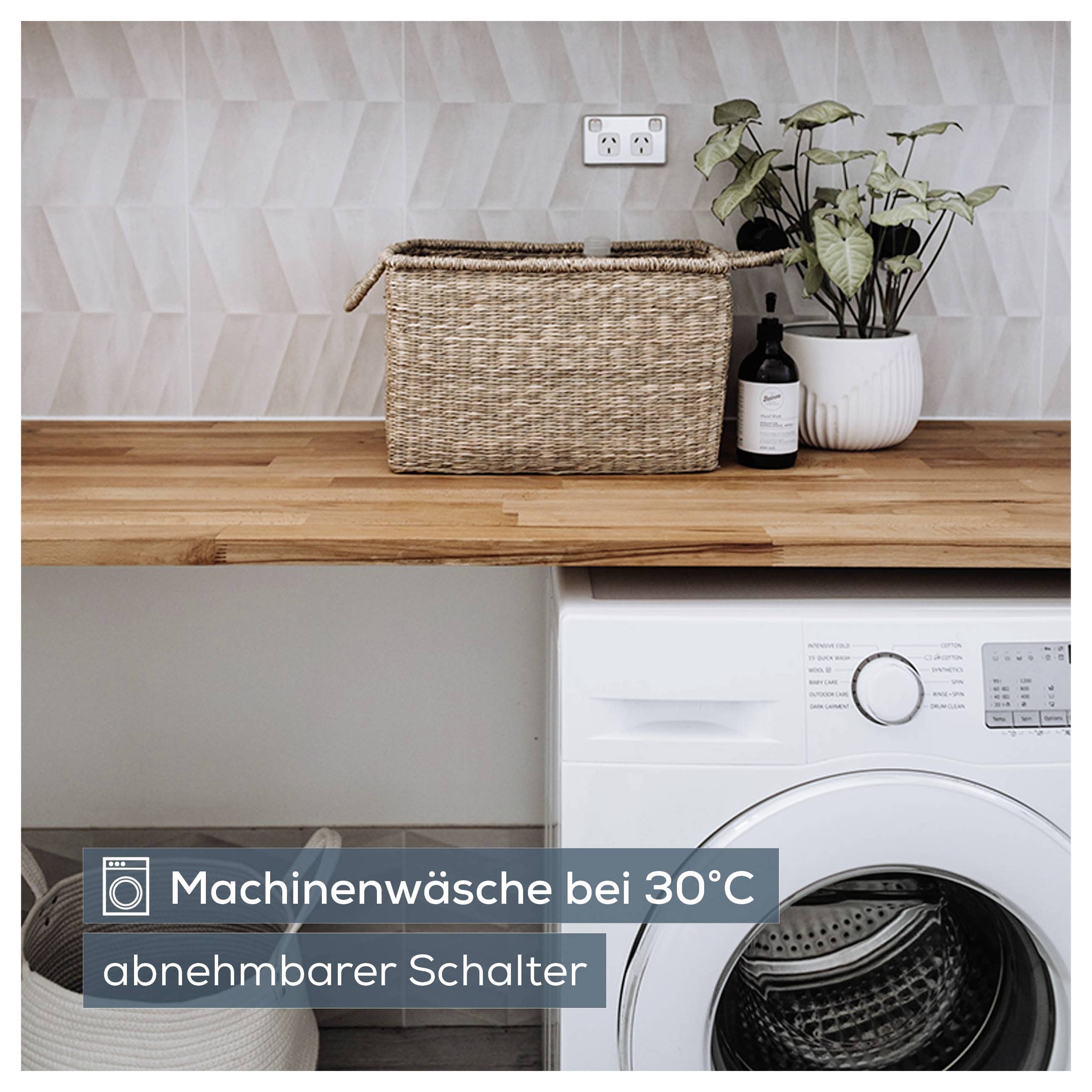 Waschmaschine im Raum mit Hinweis 'Maschinenwäsche bei 30°C abnehmbarer Schalter'.