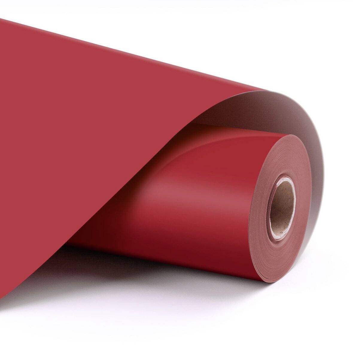 Aufgerolltes rotes Geschenkpapier auf weißem Hintergrund, teilweise abgerollt, um die Papierrolle und die Schnittkante zu zeigen.