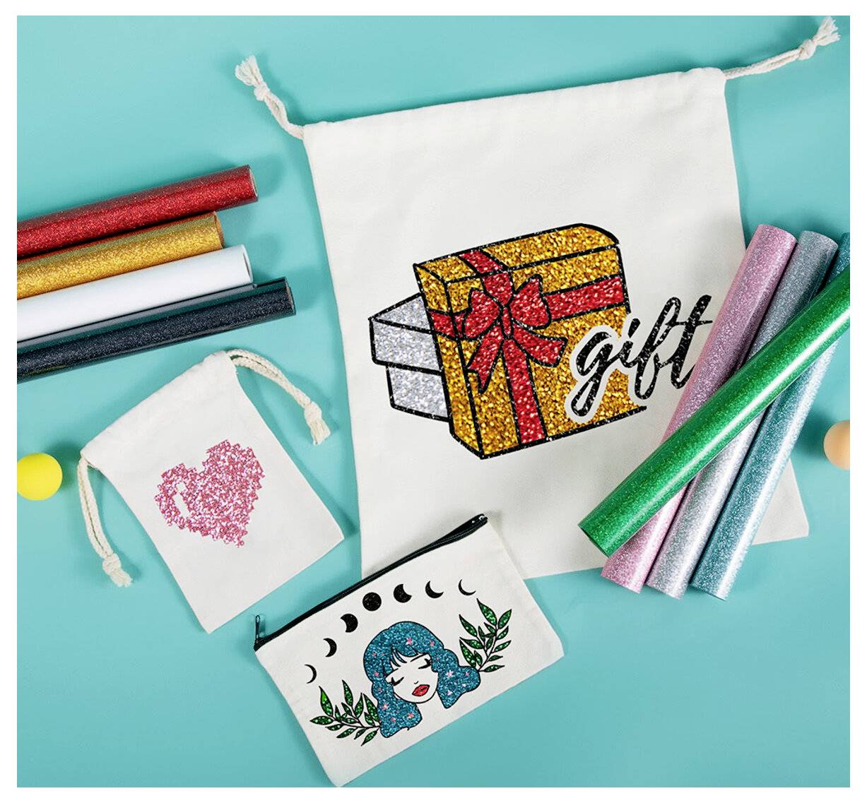Bastelbedarf auf türkisfarbenem Hintergrund mit verzierten Beuteln und Geschenktasche, einschließlich Glitter-Vinytrollen und einem glitzerndem Geschenkboxdesign.