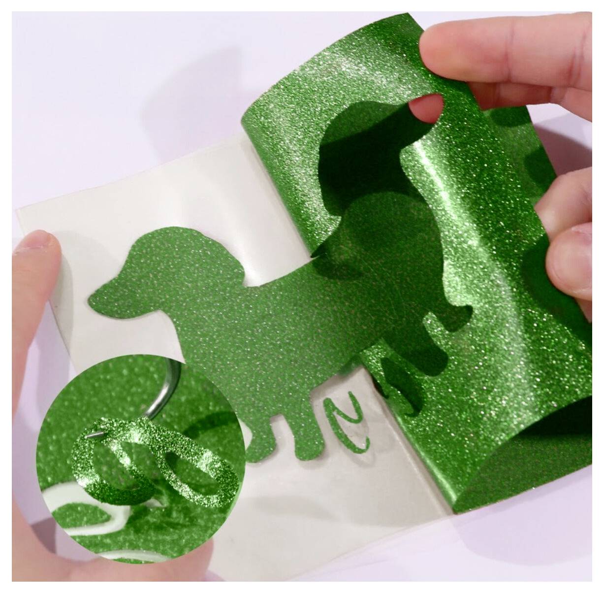 Hände schälen einen glitzernden, grün gefärbten hundeförmigen Aufkleber oder eine Decalfolie von seinem Trägerpapier ab.