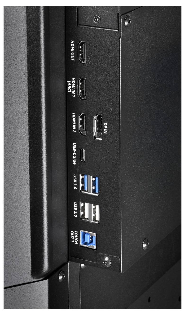 Nahaufnahme eines seitlichen Anschlussfelds eines Monitors mit HDMI-Ein- und -Ausgang, DisplayPort-Eingang, USB-C, zwei USB-3.0-Anschlüssen, USB-2.0-Anschluss und Audio-Ein-/Ausgangsbuchsen.