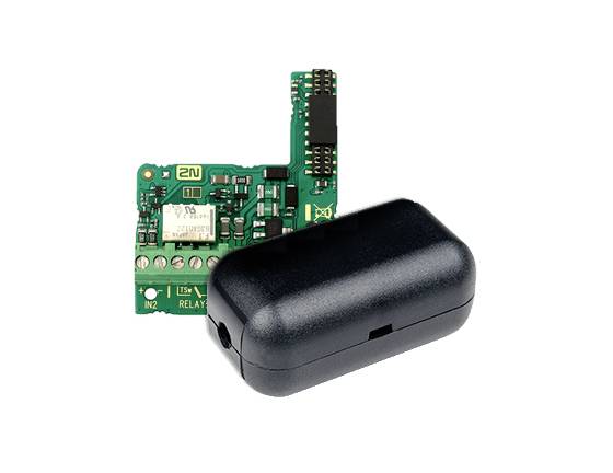 Nahaufnahme einer kleinen grünen Leiterplatte, die teilweise von einem schwarzen Kunststoff-Elektronikmodul auf weißem Hintergrund bedeckt ist.