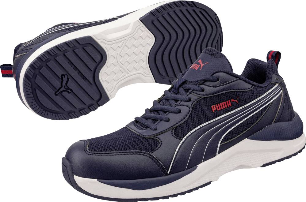 Paar marineblaue Puma-Sportschuhe, von der Seite und der Sohle gezeigt, mit weißen Mittelsohlen, schwarzem Profil und roten Logo-Akzenten.