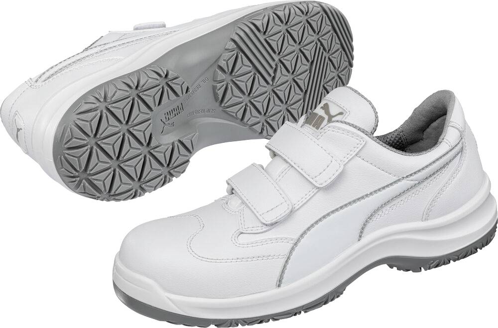 Weißer Sportschuh von oben und von der Sohle gezeigt, mit doppelten Klettverschlüssen und gemusterter grauer Lauffläche.