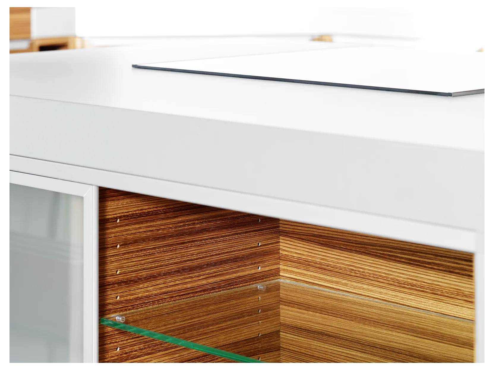 Nahaufnahme einer modernen weißen Arbeitsplatte in der Küche mit einem Glastüren-Holzschrank mit horizontaler Holzmaserung.