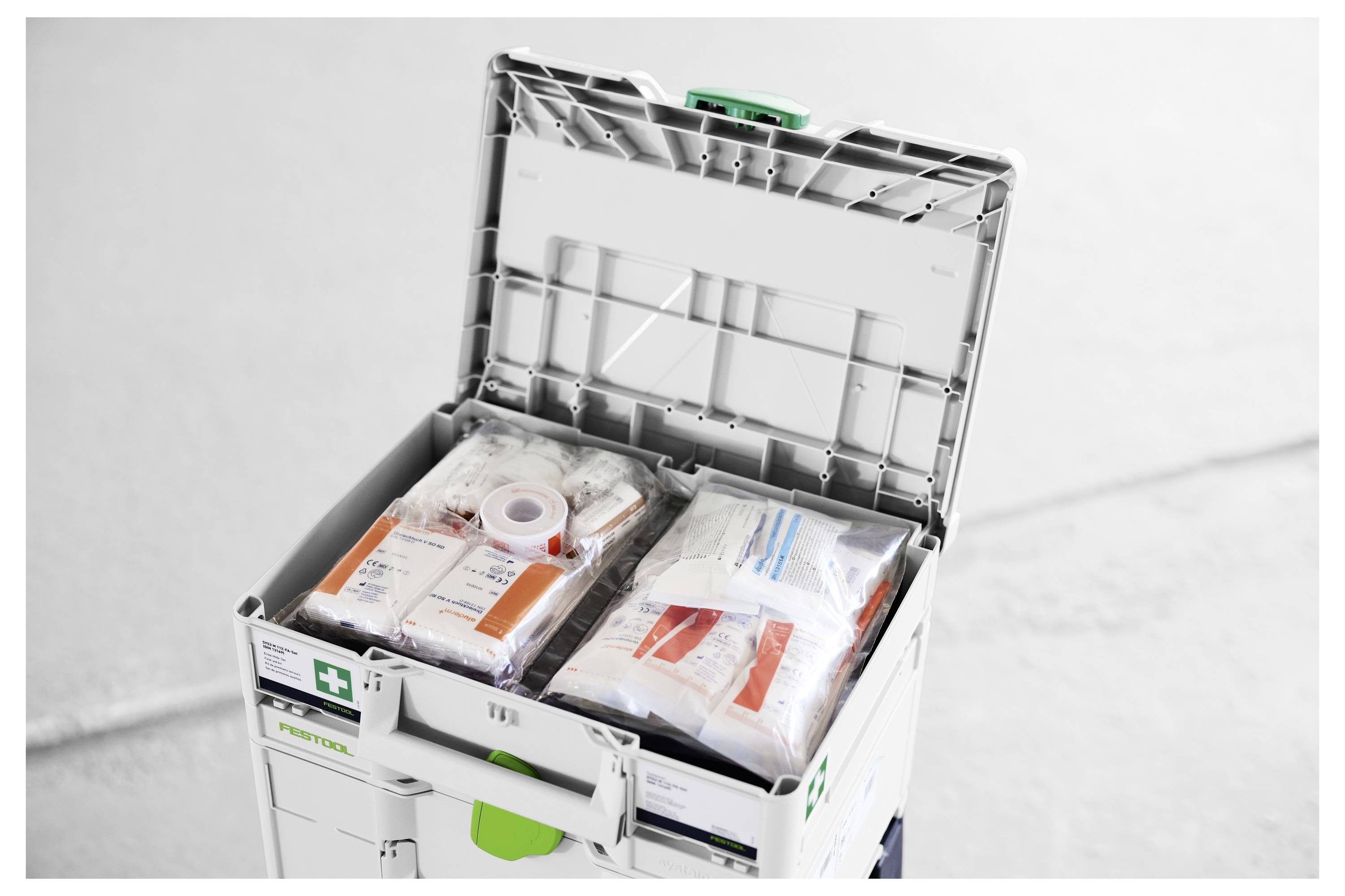 Öffnen Sie den Erste-Hilfe-Kasten mit organisierten medizinischen Verbandsmitteln und verpackten Notfallversorgungsmaterialien im Inneren.