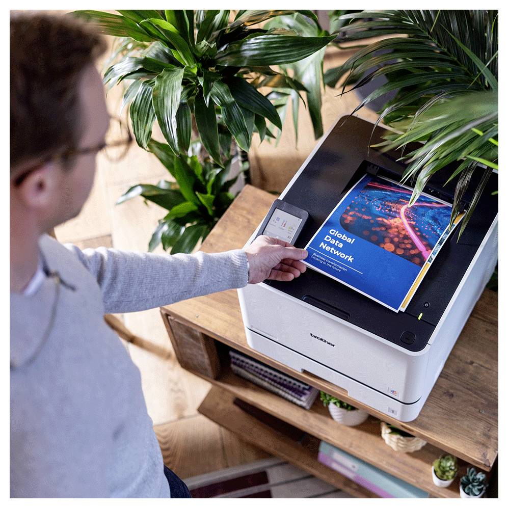 Person, die einen kompakten Drucker/Kopierer in einem Heimbüro verwendet, um ein Dokument mit dem Titel „Global Data Network