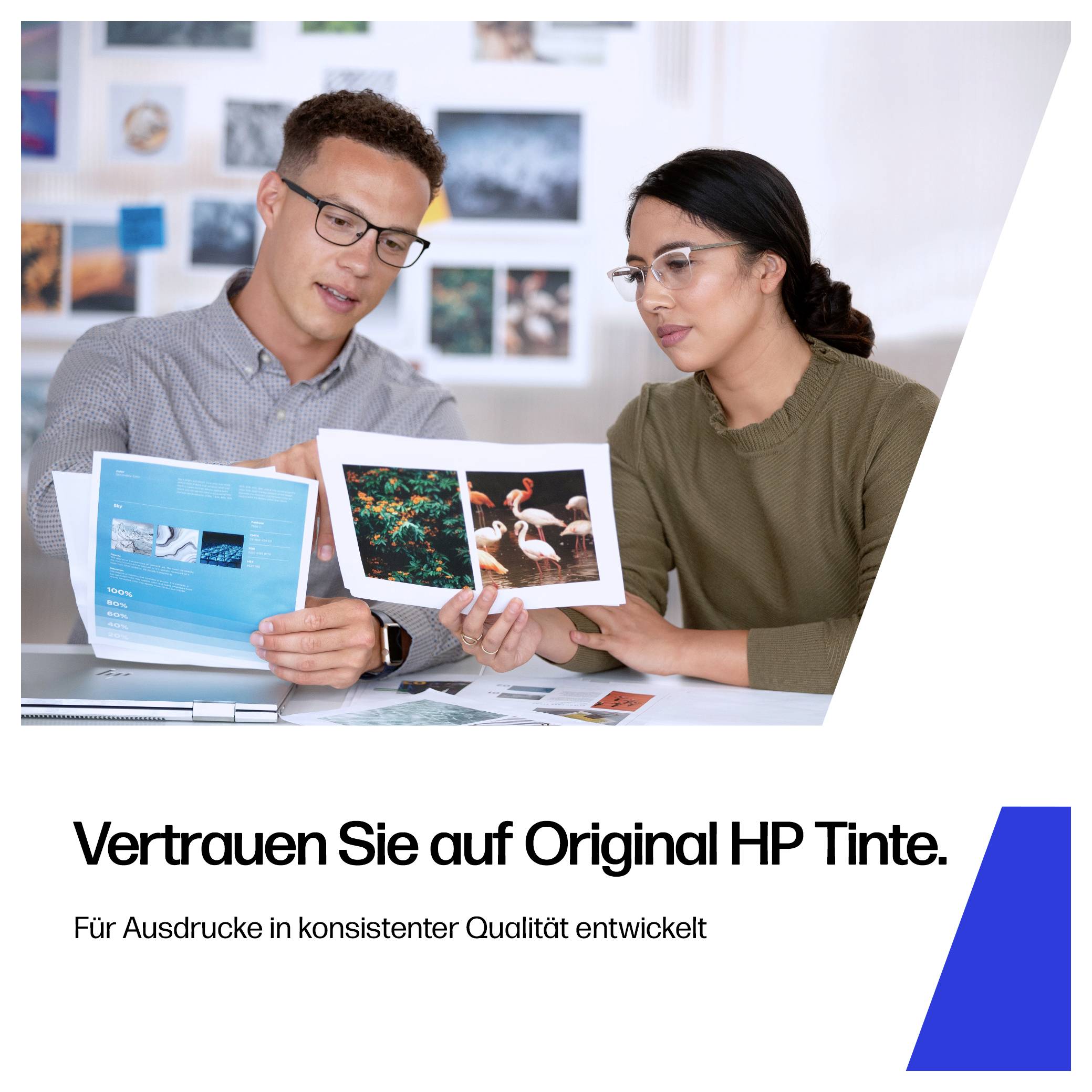 Zwei Personen überprüfen gedruckte Beispielseiten, darunter deutscher Anzeigentext: „Vertrauen Sie auf Original HP Tinte.