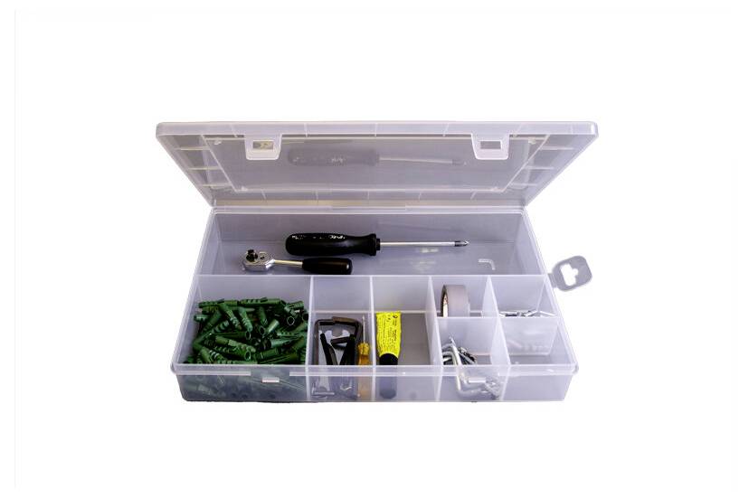 Offene Kunststoff-Organisierbox mit Fächern, die Schrauben, Schraubendreherbits, einen kleinen Schraubendreher und verschiedene Beschläge auf weißem Hintergrund enthält