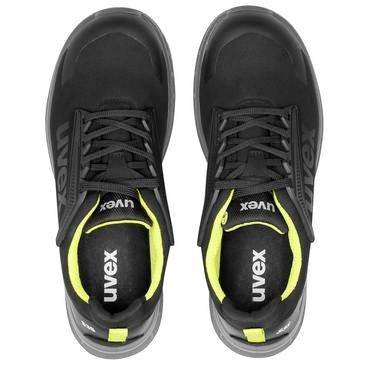 Draufsicht auf ein Paar schwarze Uvex-Sportschuhe mit neongelben Akzenten, nebeneinander auf weißem Hintergrund dargestellt.