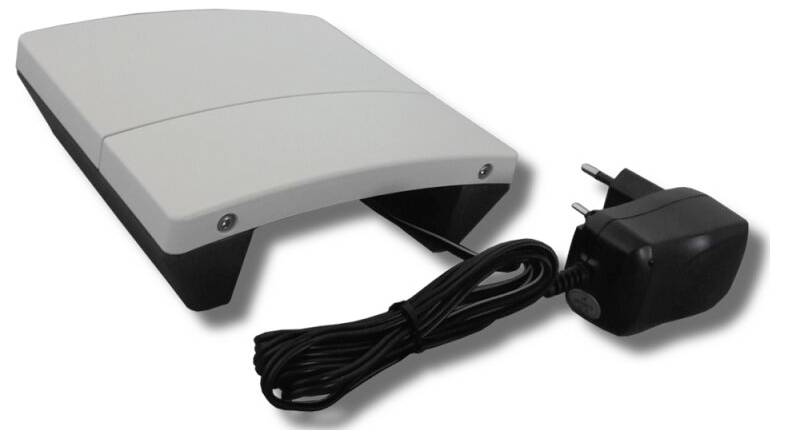 Ein grauer elektronischer Fußpedal mit einem schwarzen Stromadapter und Kabel, gezeigt auf weißem Hintergrund.
