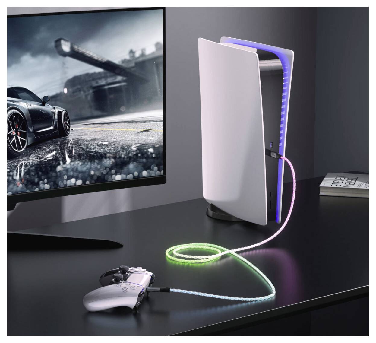 Weiße PlayStation-5-Konsole auf einem Schreibtisch mit einem leuchtenden Controller-Kabel, neben einem Monitor, der eine Rennwagenspiel-Szene zeigt.