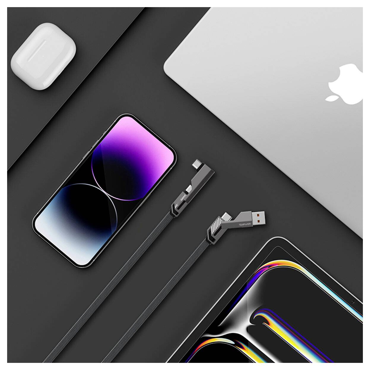 Flache Anordnung von Apple-Geräten und Zubehör auf dunklem Hintergrund: MacBook, iPhone, AirPods-Ladecase und zwei Ladekabel